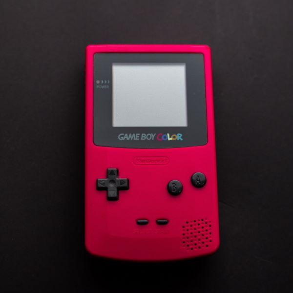 A red Gameboy Color handheld gaming system.