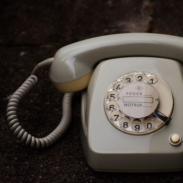 An old grey corded rotary telephone.